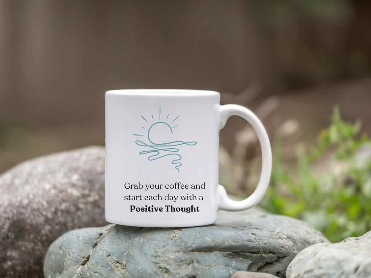 A coffee mug with the words "grab your coffee and start each day with a positive thought"